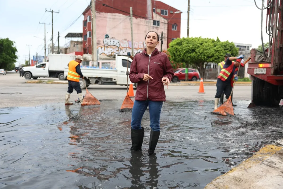Cuadrilla municipal desazolva una rejilla pluvial en una avenida de Cancún