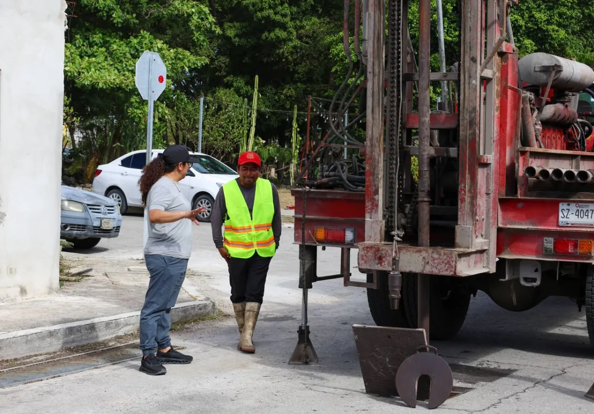 Trabajadores instalando un pozo de absorción en una avenida de Cancún